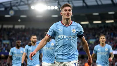 A tight action crop of a young, athletic, anonymous player in a Manchester City jersey, with a bright blue and white kit...