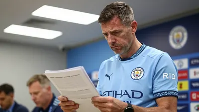 A 35-year-old Manchester City scout, dressed in the team's sky blue home shirt with navy sleeves and the Manchester City...