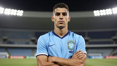 A 22-year-old Brazilian winger in a sky blue football kit, standing confidently with arms crossed, looking determined
