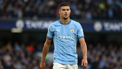 A 35-year-old, 5'9" tall, athletic-looking Manchester City midfielder with a strong build, wearing a blue jersey made of...