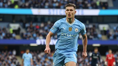 A tight action crop of a 25-30-year-old Manchester City midfielder, wearing a sky blue jersey with a white collar, and...